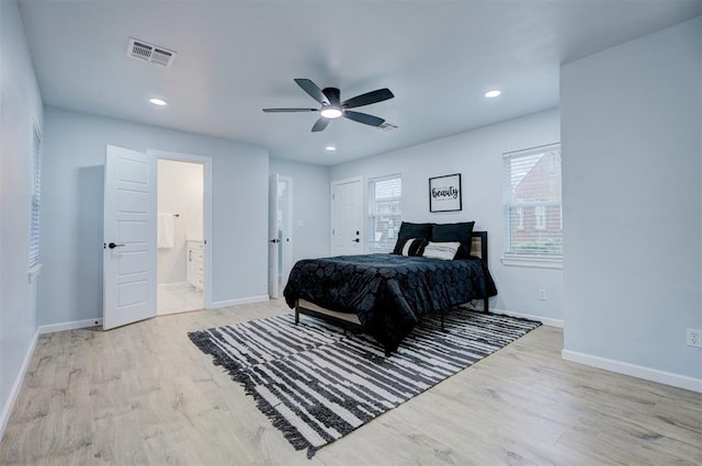 bedroom featuring ceiling fan, ensuite bath, and light hardwood / wood-style flooring