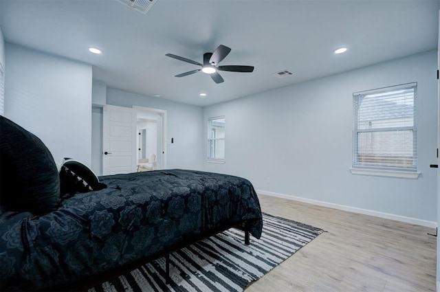 bedroom featuring multiple windows, light hardwood / wood-style flooring, and ceiling fan