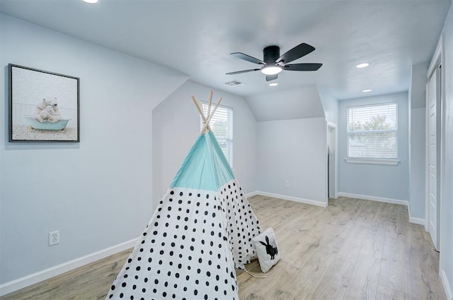 rec room featuring vaulted ceiling, a wealth of natural light, ceiling fan, and light hardwood / wood-style floors