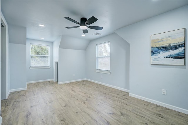 additional living space with plenty of natural light, vaulted ceiling, ceiling fan, and light wood-type flooring