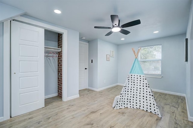 recreation room with ceiling fan and light hardwood / wood-style floors