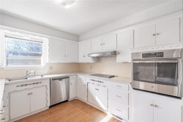 kitchen featuring appliances with stainless steel finishes, light hardwood / wood-style floors, sink, and white cabinets