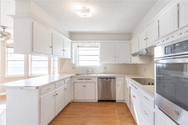 kitchen featuring stainless steel appliances, light hardwood / wood-style flooring, white cabinets, and kitchen peninsula