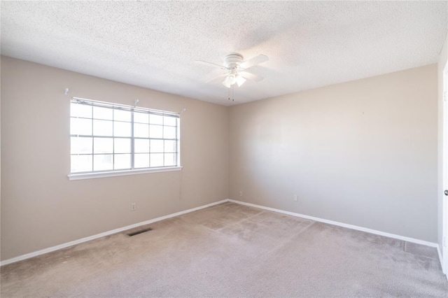 empty room with carpet flooring, a textured ceiling, and ceiling fan