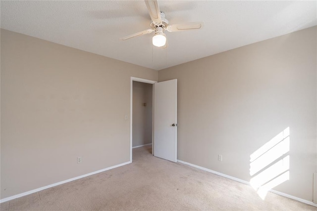 carpeted empty room featuring ceiling fan and a textured ceiling