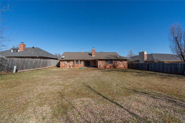 rear view of house featuring a yard