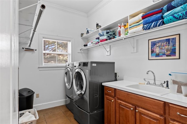 washroom featuring washer and dryer, sink, cabinets, ornamental molding, and light tile patterned floors