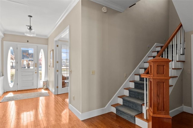 foyer featuring crown molding and light hardwood / wood-style floors