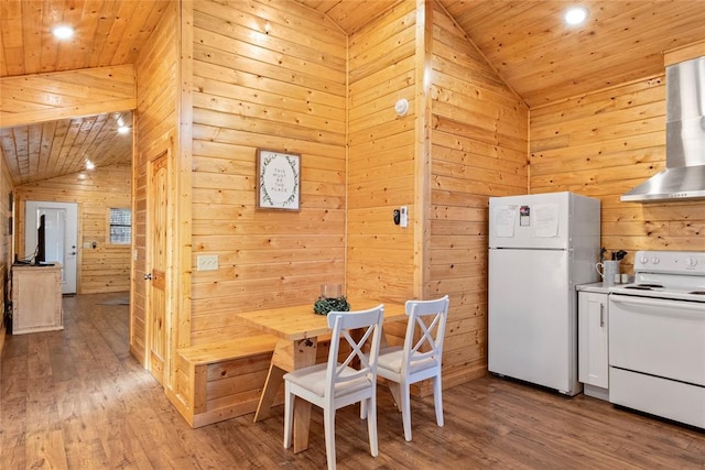 dining area with hardwood / wood-style flooring, lofted ceiling, wooden walls, and wood ceiling