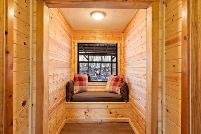 unfurnished room with hardwood / wood-style flooring, a textured ceiling, and wood walls