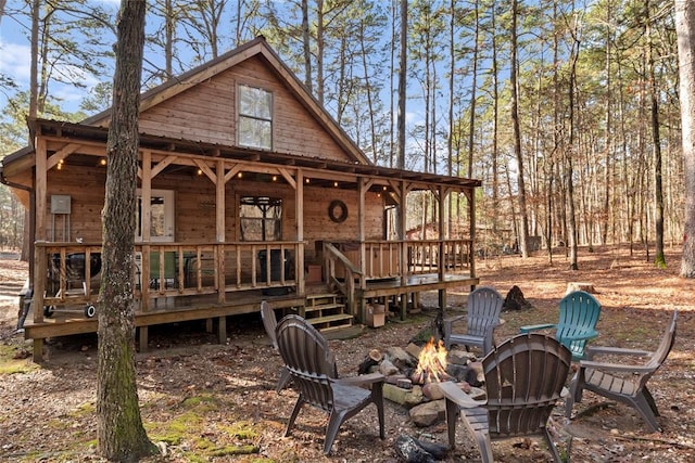 back of property featuring a porch and a fire pit