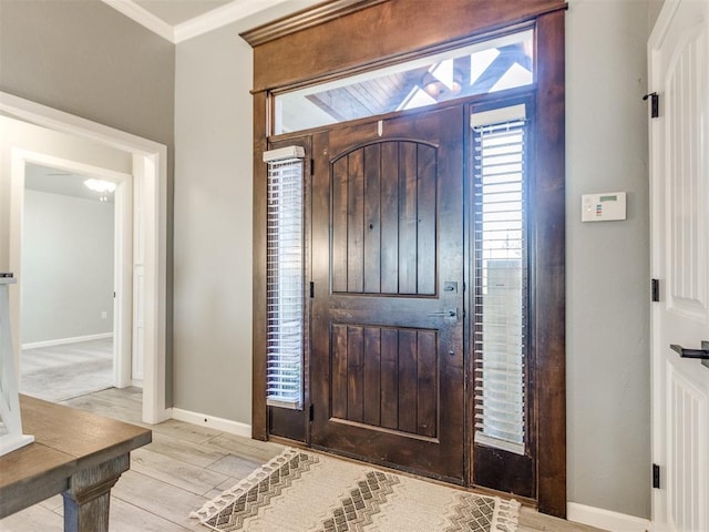 foyer featuring crown molding and light hardwood / wood-style floors