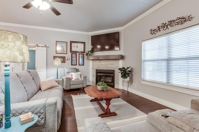 living room featuring ornamental molding, a barn door, dark hardwood / wood-style floors, and ceiling fan