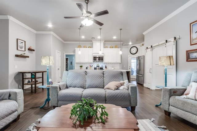 living room with crown molding, dark hardwood / wood-style floors, a barn door, and ceiling fan