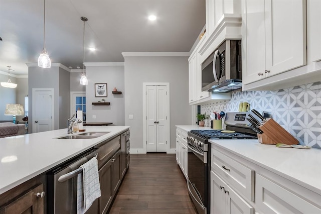 kitchen with sink, white cabinetry, decorative light fixtures, appliances with stainless steel finishes, and backsplash