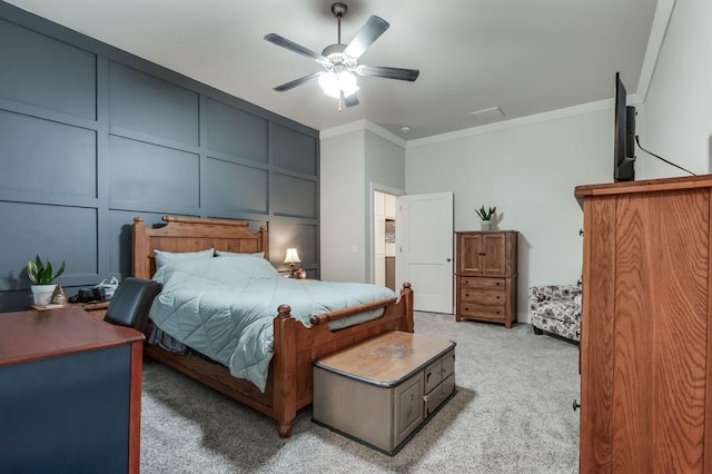 carpeted bedroom featuring ornamental molding and ceiling fan