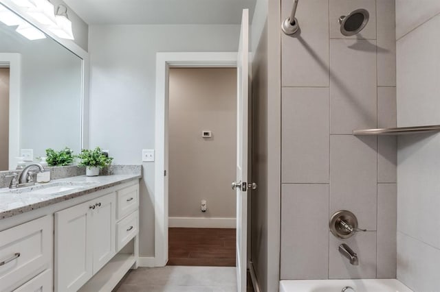 bathroom featuring hardwood / wood-style flooring, shower / washtub combination, and vanity