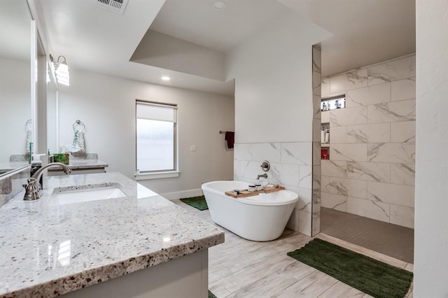 bathroom featuring vanity and shower with separate bathtub