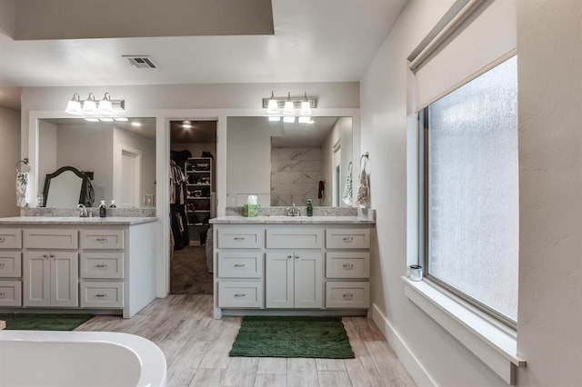 bathroom featuring vanity, hardwood / wood-style flooring, and a healthy amount of sunlight