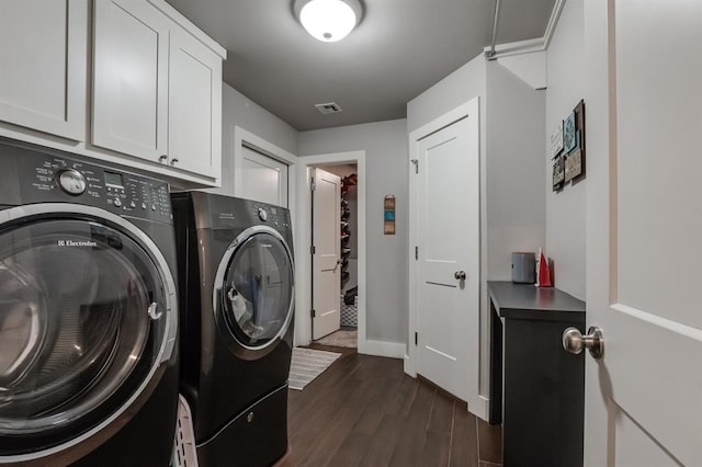 laundry area with cabinets, washing machine and clothes dryer, and dark hardwood / wood-style flooring