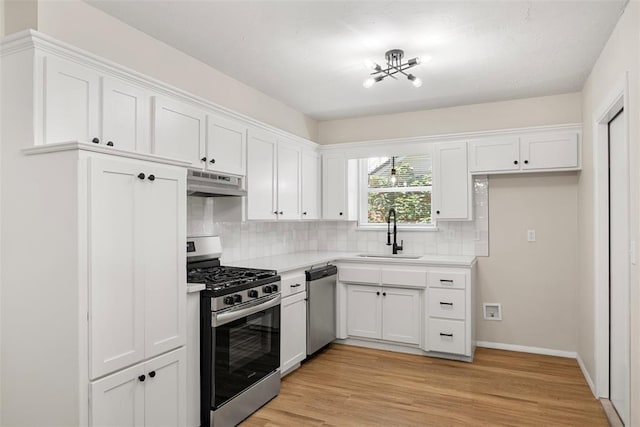 kitchen featuring sink, white cabinetry, tasteful backsplash, light wood-type flooring, and stainless steel appliances