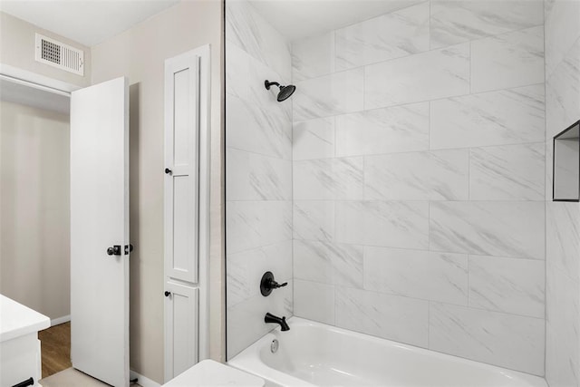 bathroom featuring tiled shower / bath and vanity