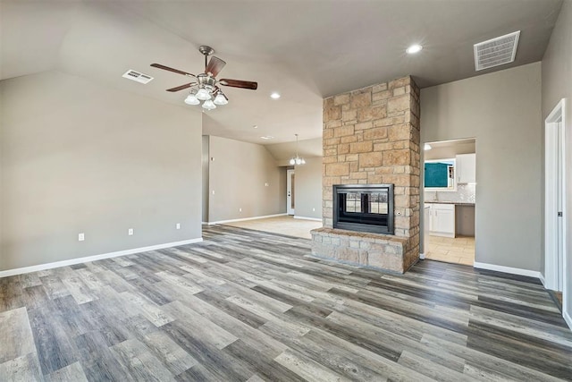 unfurnished living room featuring ceiling fan, lofted ceiling, hardwood / wood-style floors, and a fireplace