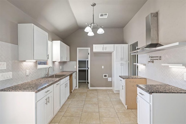 kitchen featuring white cabinetry, sink, pendant lighting, and wall chimney exhaust hood