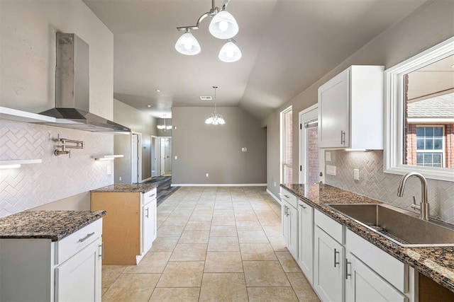 kitchen featuring ventilation hood, sink, hanging light fixtures, and white cabinets