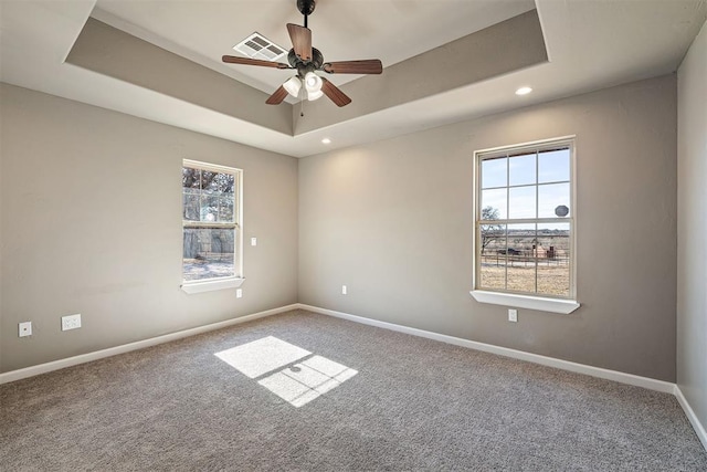 unfurnished room featuring ceiling fan, a tray ceiling, and carpet floors