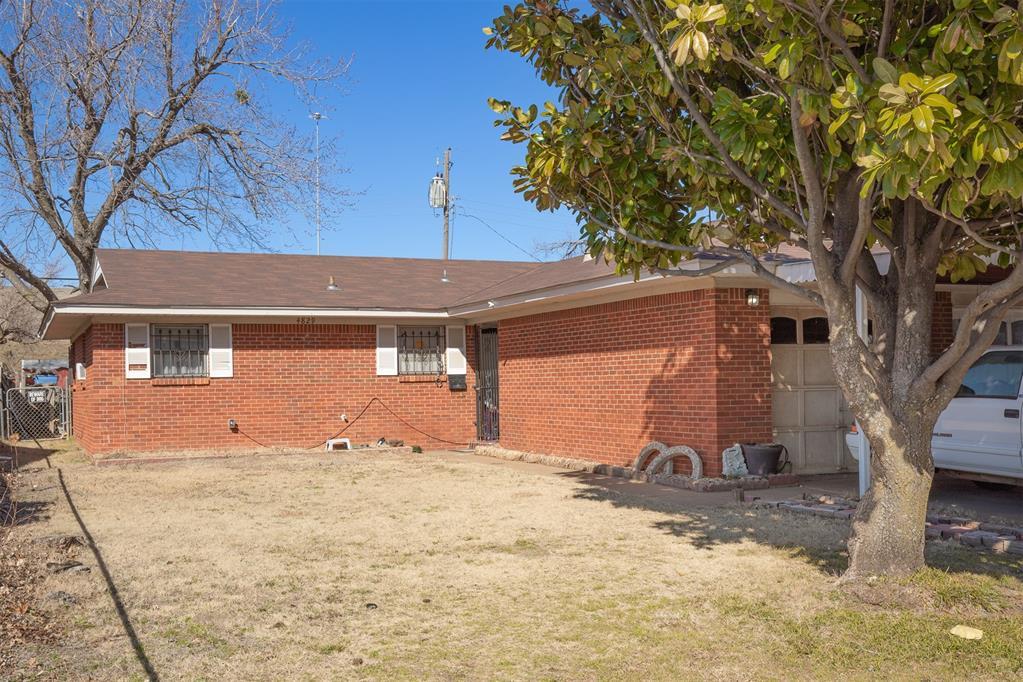 rear view of property with a garage and a lawn