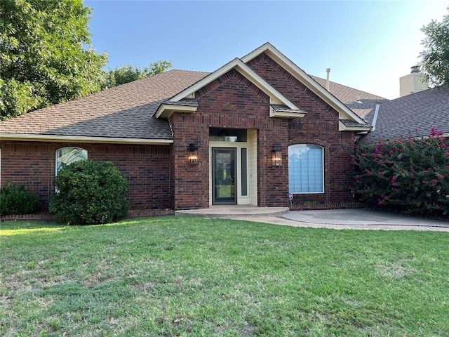 view of front of home with a front yard and a patio area