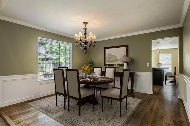 dining room with ornamental molding, dark wood-type flooring, and a chandelier