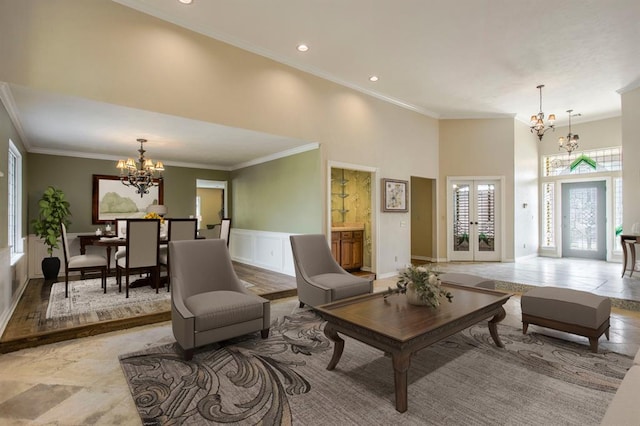 living room featuring a high ceiling, ornamental molding, and a chandelier