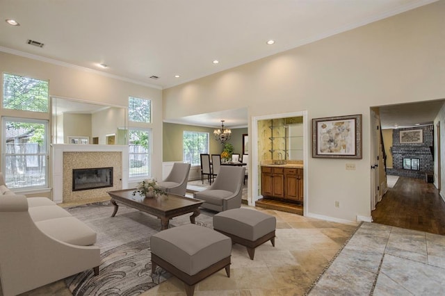 living room with a high ceiling, ornamental molding, and a chandelier