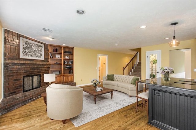 living room with a fireplace and light wood-type flooring