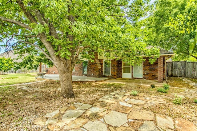 view of property hidden behind natural elements featuring a patio