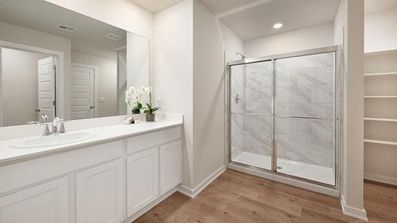 10225 NW 28th St, Yukon, OK 73099 - bathroom with vanity, hardwood / wood-style flooring, and walk in shower
