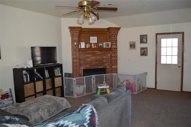 carpeted living room featuring a brick fireplace and ceiling fan