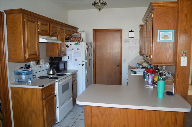 kitchen featuring light tile patterned floors, white appliances, and kitchen peninsula