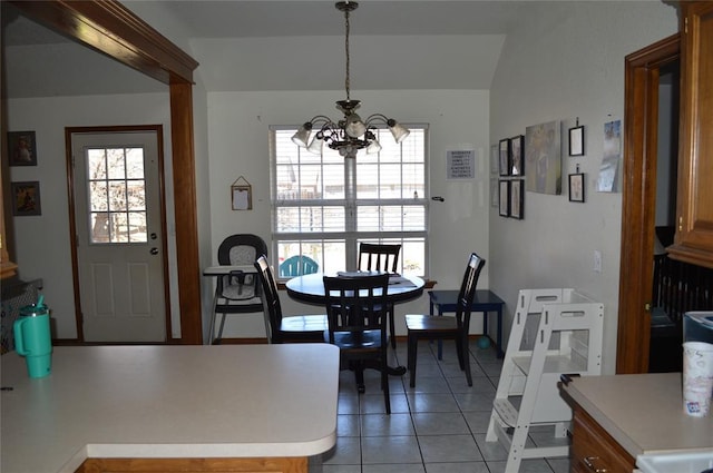 tiled dining area featuring a healthy amount of sunlight and a notable chandelier