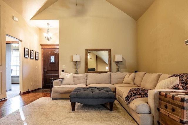 living room with hardwood / wood-style flooring, high vaulted ceiling, and a chandelier