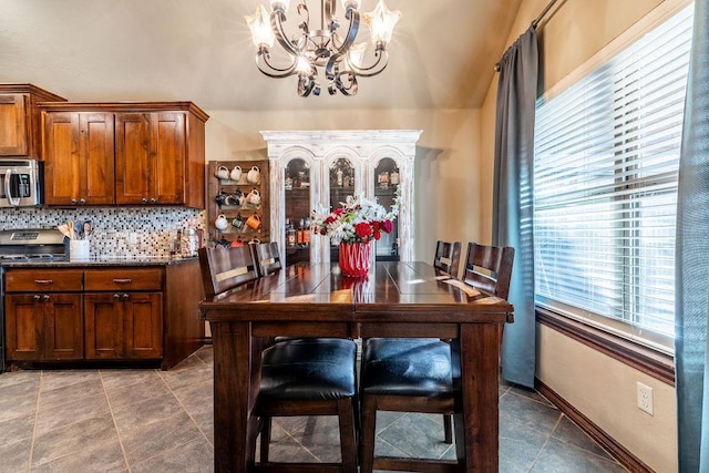 kitchen with hanging light fixtures, appliances with stainless steel finishes, an inviting chandelier, and decorative backsplash