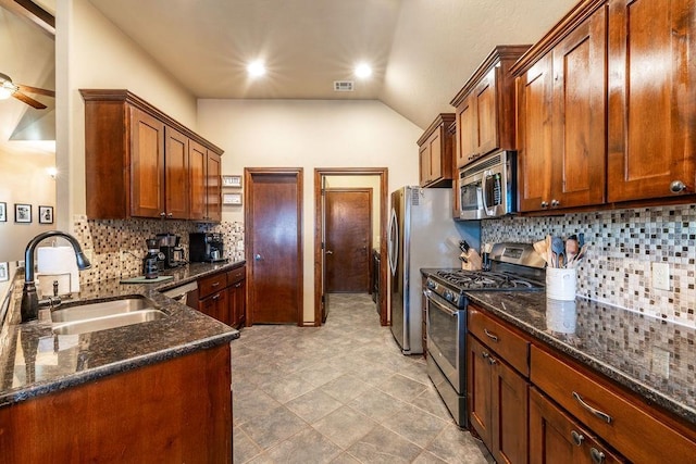 kitchen featuring sink, dark stone counters, ceiling fan, and appliances with stainless steel finishes