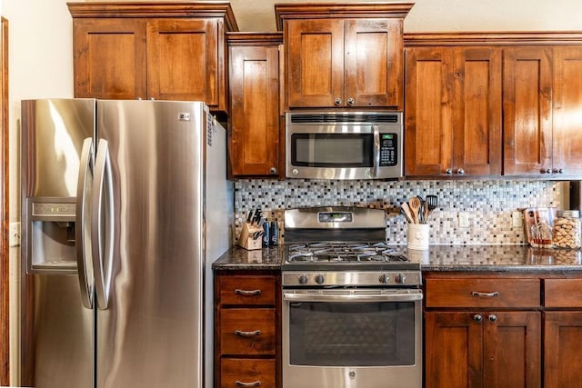 kitchen featuring appliances with stainless steel finishes, decorative backsplash, and dark stone counters