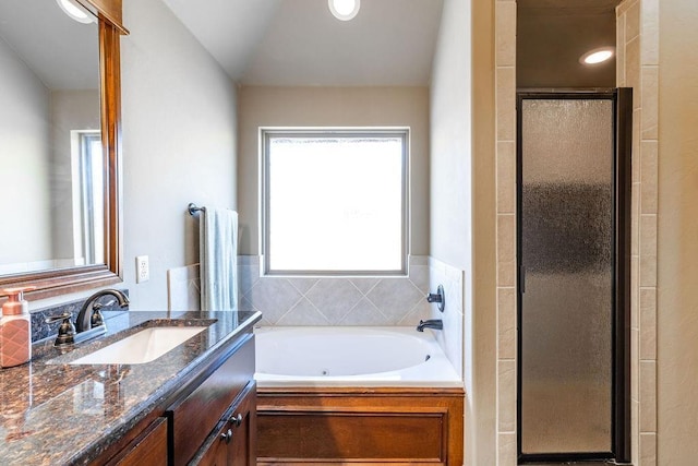 bathroom with vanity and shower with separate bathtub