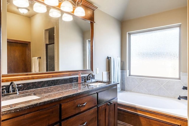 bathroom featuring vanity, lofted ceiling, and a washtub