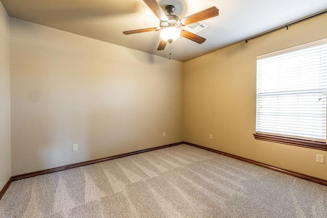 spare room featuring light colored carpet and ceiling fan