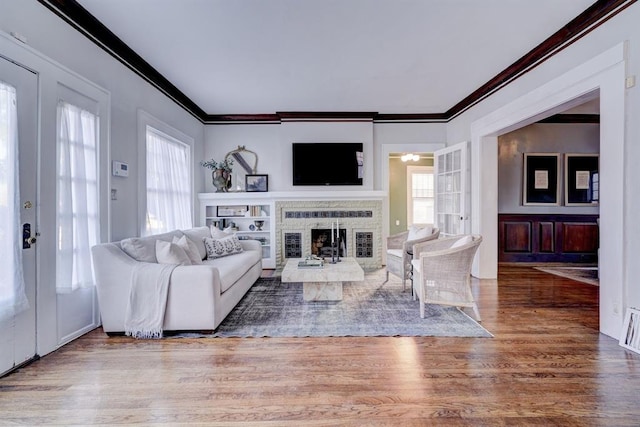 living room with french doors, ornamental molding, and plenty of natural light