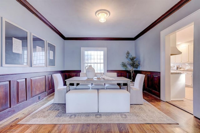 dining room featuring ornamental molding and light hardwood / wood-style floors